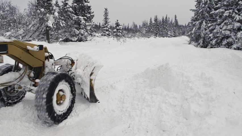 A road grader clears snow off a rural road after a snowstorm in an unidentified