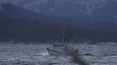 HOMER, AK - JANUARY 2013 - Frigid salt water spray splashes over the bow of a fishing boat in Kachemak Bay IN January 2013 near Homer, Alaska