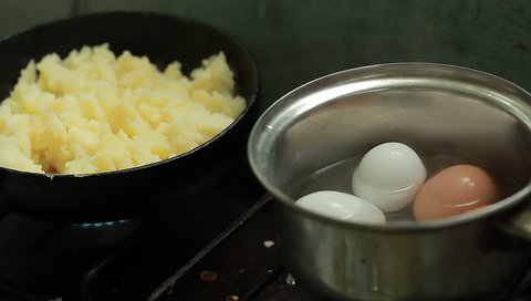 potatoes and eggs are cooked on a gas stove