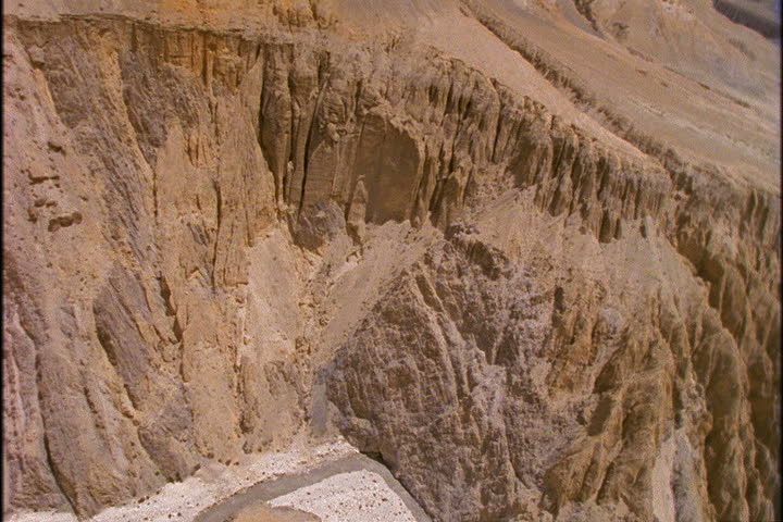 Low aerial past striated cliffs in Lo Monthang, Nepal.