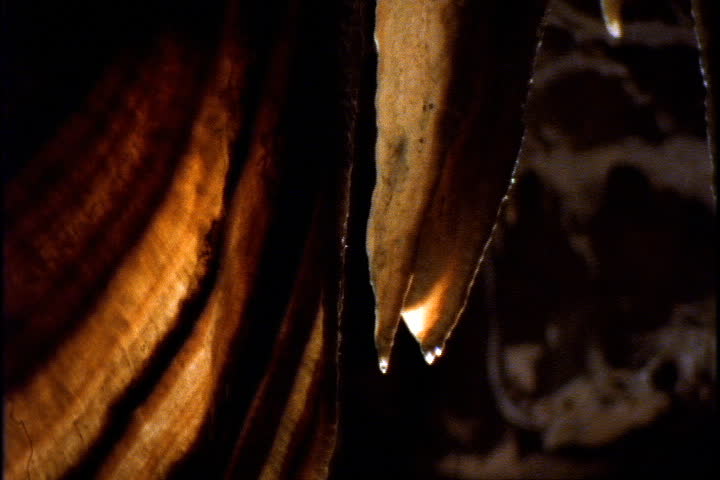 Tilt down dripping stalactite near curtain formation in Wolverine Cave in Yorkshire, England.