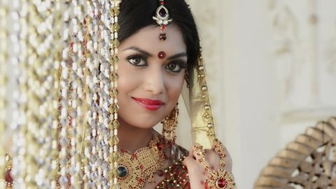 Pan shot of a happy Indian bride posing
