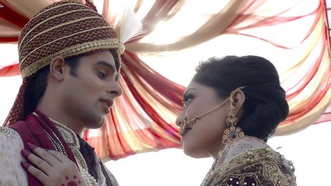 Shot of Indian bride and groom in traditional wedding dress talking to each other 庫存影片