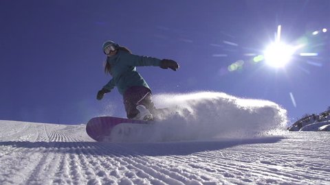 SLOW MOTION: Snowboard girl spraying snow into camera