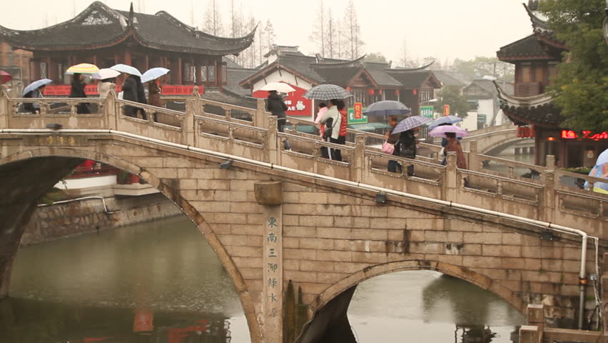 SHANGHAI - DECEMBER 16: Qibao Ancient Town stone arch bridge and boat on rainy