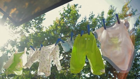 baby clothes hanging on a rope and drying