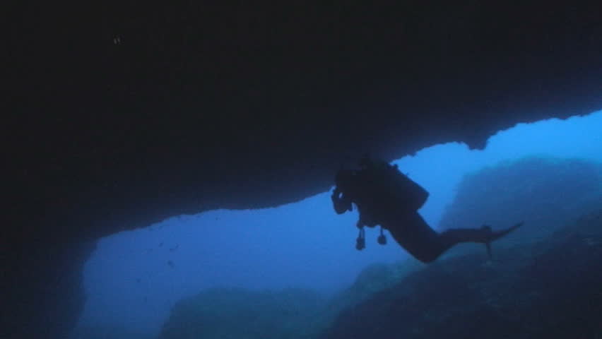 scuba divers in cave