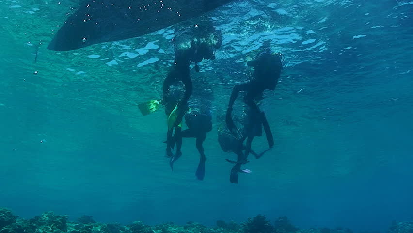 scuba divers at zodiac, under water view