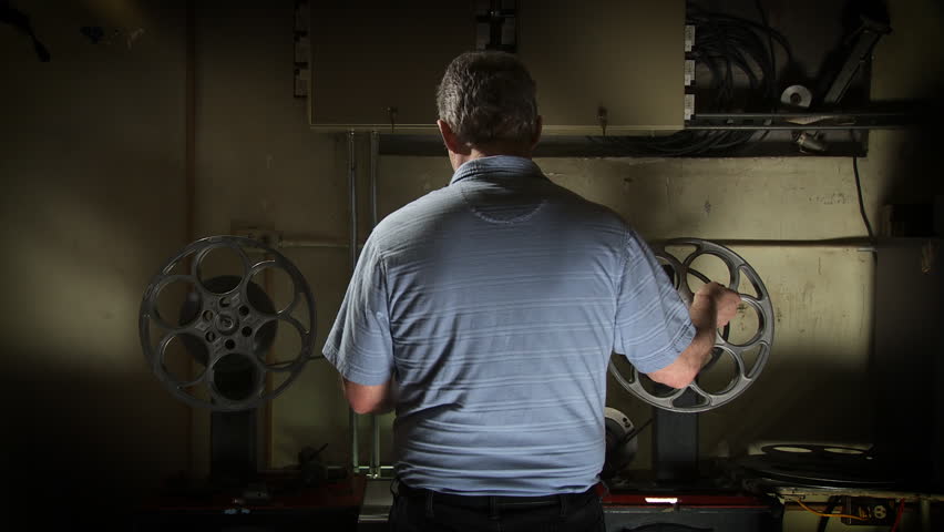 Projectionist inspects a 35mm film print.