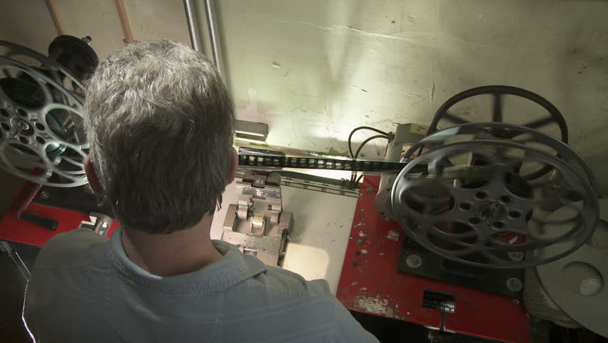 Over the shoulder view of projectionist making a splice in a 35mm film print.