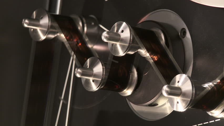 Detail of 35mm film moving around tension rollers in a telecine machine in a