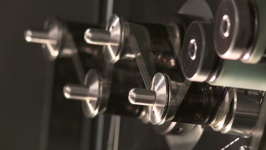 Detail of 35mm film moving continuously at 24fps around tension rollers in a
