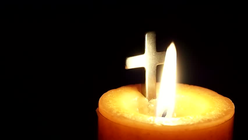 Candle burning with a christian cross. Great to use in your religious projects.