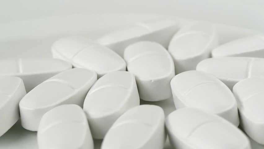 White pills rotating on a turntable