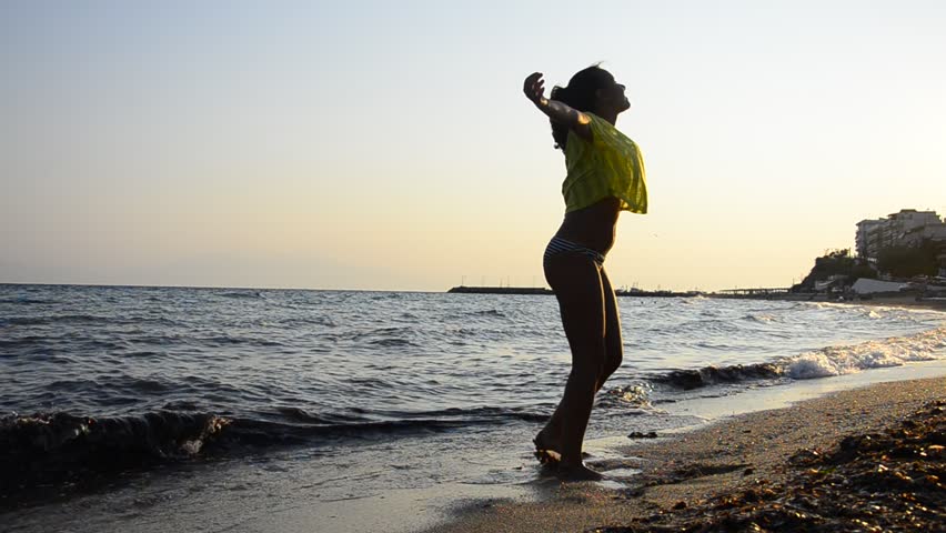 Human, Beautiful young girl turns spiritual on a beach sand at sunset