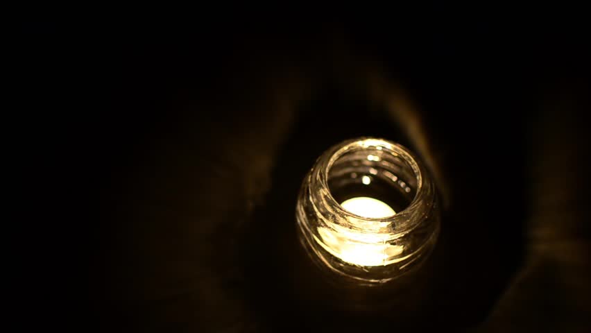 Candle in blackness, A candle in glass candelabra sit in the corner of the frame