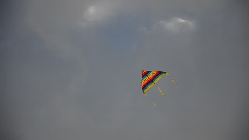 High Flying Kite. High flying kite sailing in a blue sky with soft faint clouds.