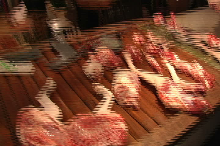 Freshly butchered dog meat on counter, zoom to head on block in Guangzhou, China.
