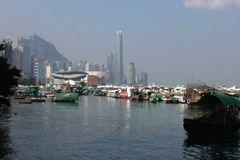 HONG KONG, CHINA - OCTOBER 24, 2004: Junk passes through Victoria Harbor with skyline behind.