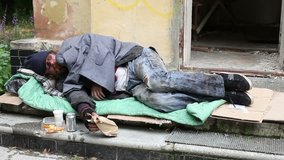 Homeless man sleeping in the open air on the porch of an abandoned house