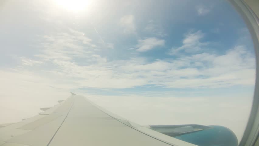 View of sky and wing of plane flying through clouds, Time Lapse 