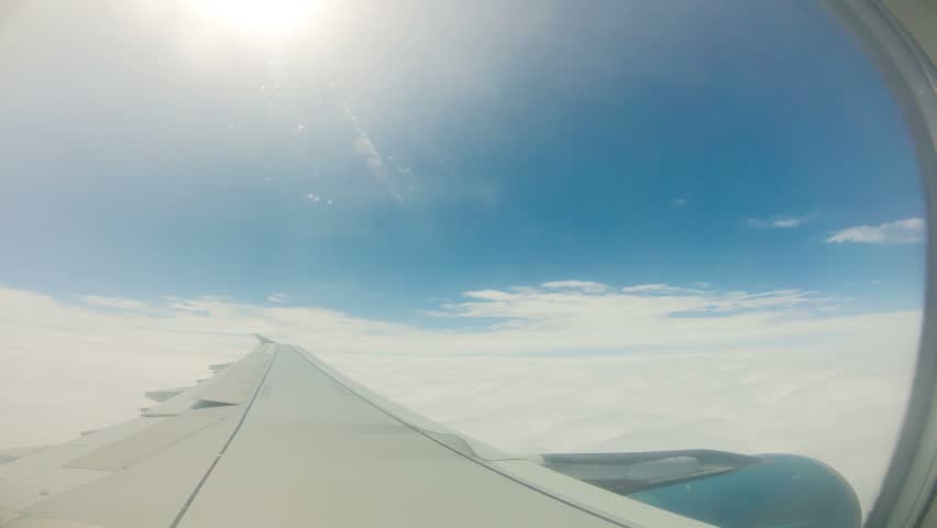 View of sky and wing of plane flying through clouds, Time Lapse 