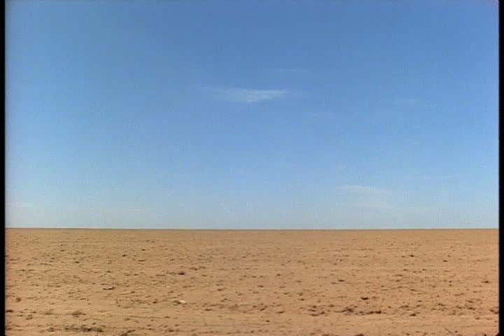 Flat field of dirt under blue sky in Oklahoma Panhandle, Oklahoma.