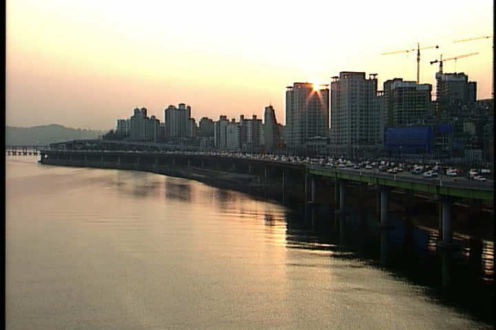  Han River at sunset, with rush hour traffic and skyline in Seoul, South Korea.