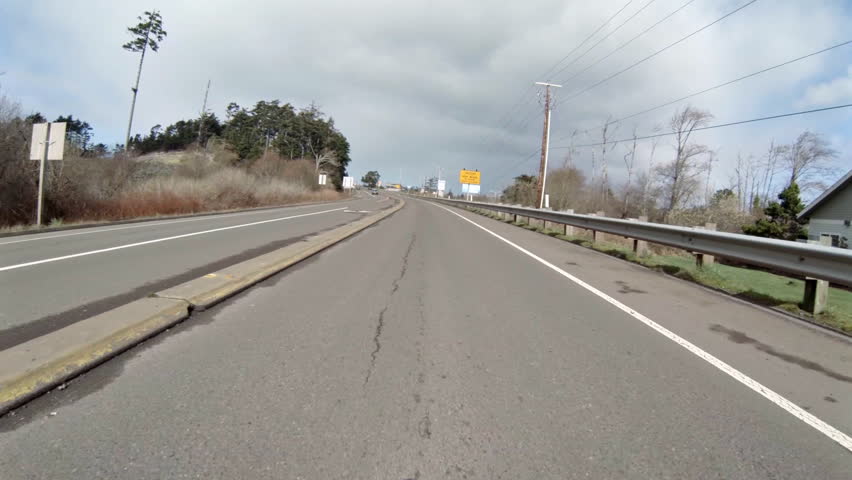 Time lapse of car driving north on Highway 101, crossing Yaquina Bay Bridge, in