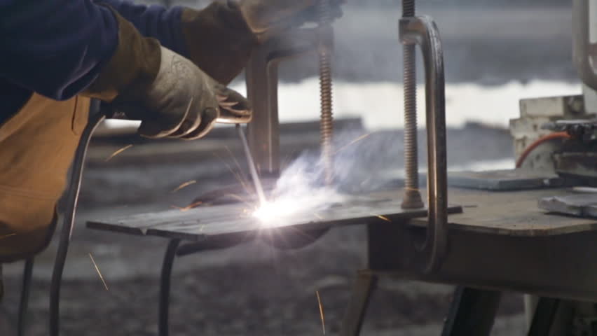Close-up view of industrial welder joining two plates of steel together