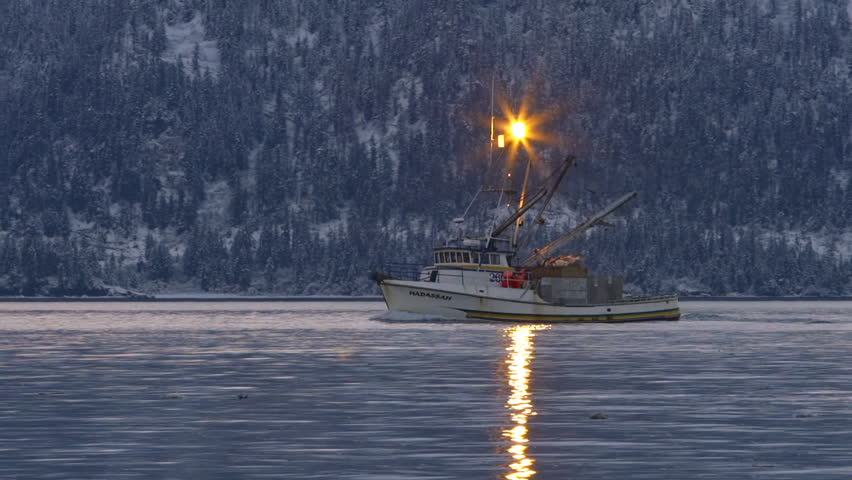 HOMER, AK - FEBRUARY 2013 - A small private fishing boat returns to port on a