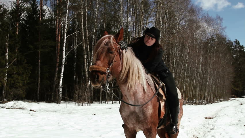 girl cowboy sitting on a horse in winter