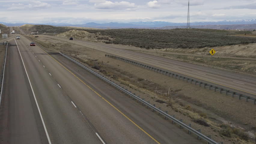 View from a highway overpass of cars and trucks driving southbound on Interstate