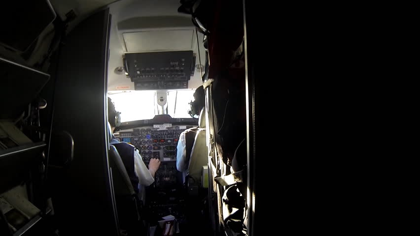 View through cockpit of pilots landing a twin turbo-propeller airplane on a