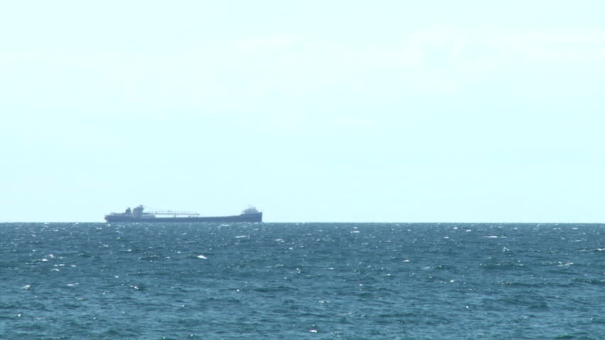 Container ship sailing on the horizon, through the Great Lakes Shipping Channel