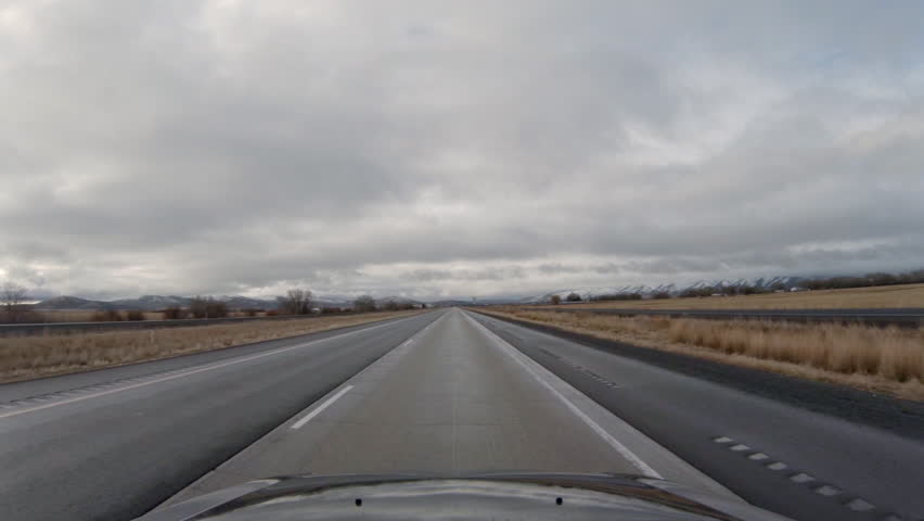 Stormy clouds threaten to break over car driving southbound on Interstate 84 in