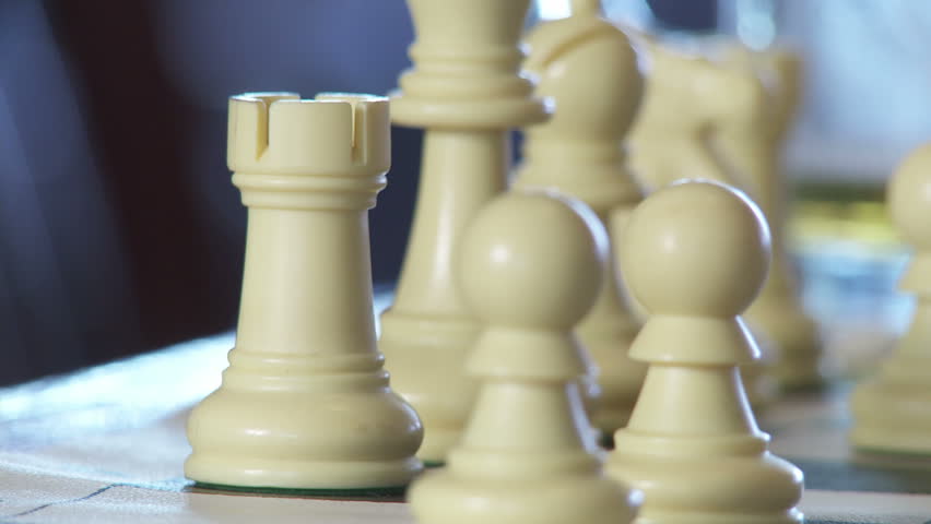 Three close up shots of hands moving chess pieces.