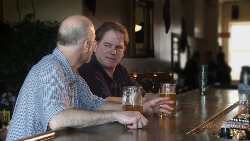 Two men talking and drinking at a local bar.
