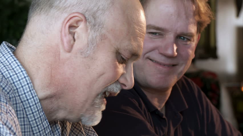 Close up on two guys talking at a bar, focus pull from foreground to background