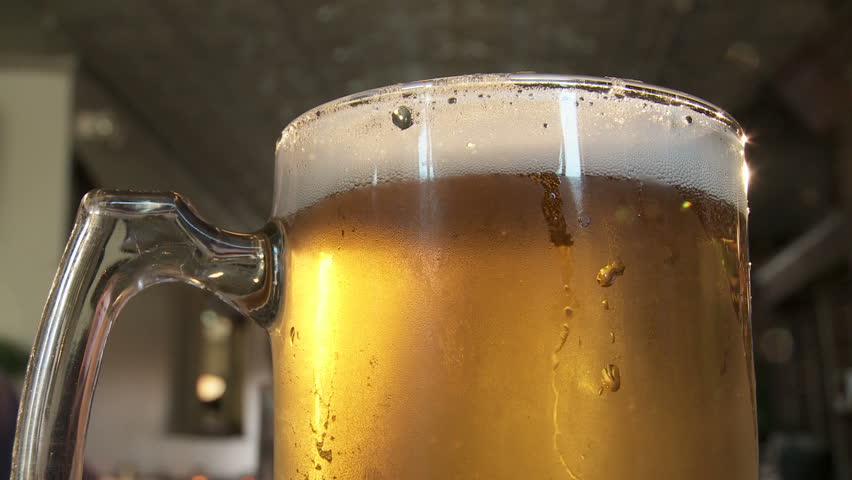 Close up on the top of a glass of lager.  Loopable clip.