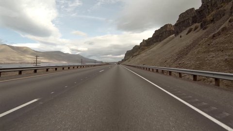 Driving POV in Oregon on highway 84 with desolate empty mountain landscape