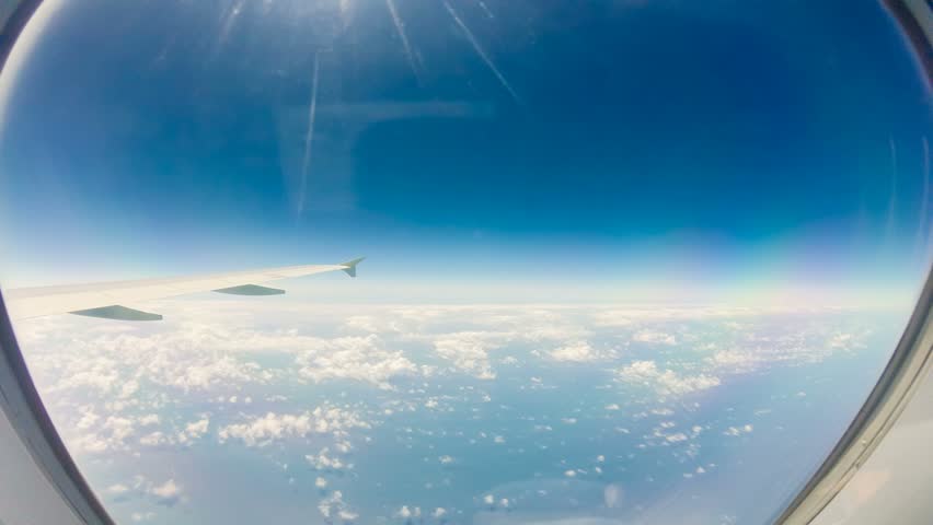 View of sky and wing of plane flying through clouds, Time Lapse 