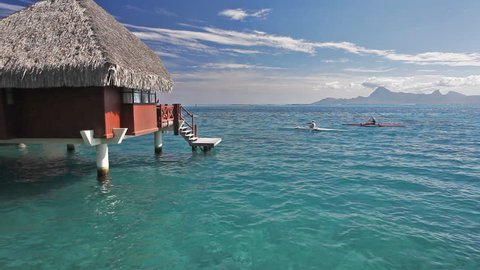 Man on kayaks next to over water bungalow