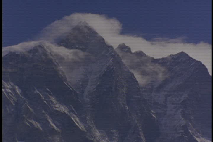  Close up of peak surrounded by swirling clouds and mist in Nepal.