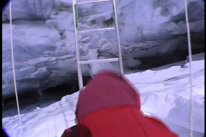 POV of climber, looking down into crevasse while crossing on ladder in Nepal.