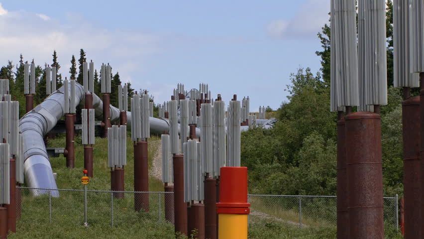 Zoom out from hillside installation scene of Alaska's Oil Pipeline to reveal a