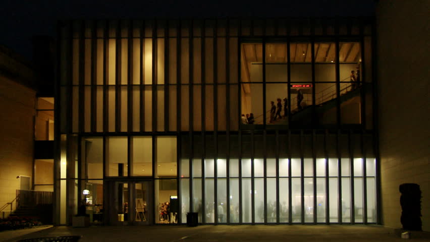 Exterior of a building with lots of glass revealing and concealing the people