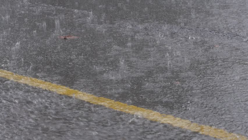 Heavy rain falling on road