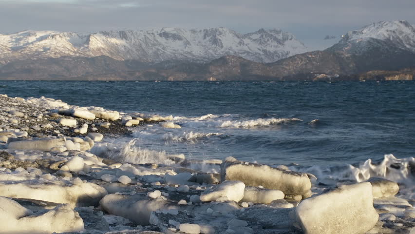 Frigid surf of Kachemak Bay washes over ice chunks on the beach at Land's End,