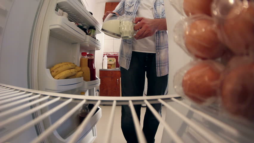 Man opening door of fridge to get milk and closes door. Intro. 